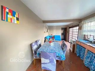 Foto de uma sala de jantar com mesa e cadeiras azuis em uma residência.