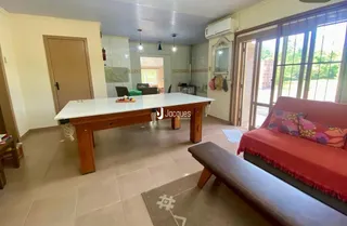 Sala de estar com mesa de madeira e sofá vermelho em uma residência.
