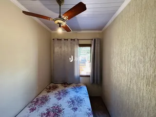 Quarto interno com janela e cortinas.