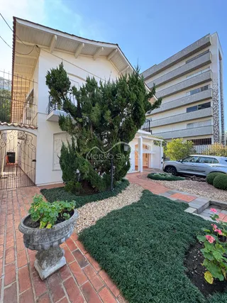 Fachada de uma residência em Lajeado, Brasil, com jardim frontal e muro de ferro.