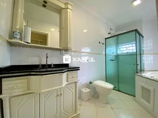 Banheiro com bancada branca e armários em um ambiente claro.