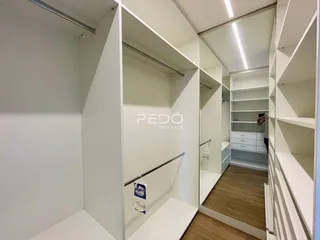 Hall de entrada com paredes brancas e espelhos em um imóvel no Brasil.