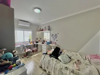 Quarto com cama e estante em um imóvel no Brasil.