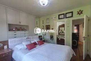 Quarto com cama grande e armários brancos.