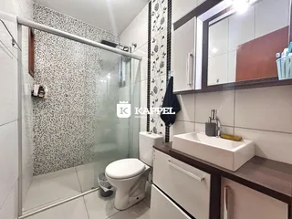 Banheiro com box de vidro e bancada moderna.