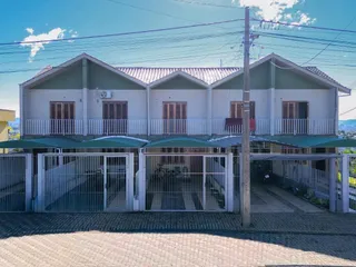 Fachada de uma casa de dois andares em Lajeado, Brasil, com varanda e portão de acesso.