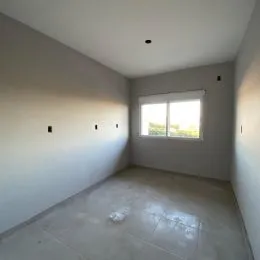 Foto de um cômodo interno com paredes brancas e piso claro.