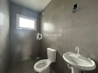 Banheiro moderno com janela e azulejos claros.