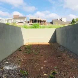 Vista externa de um terreno delimitado por muros altos.