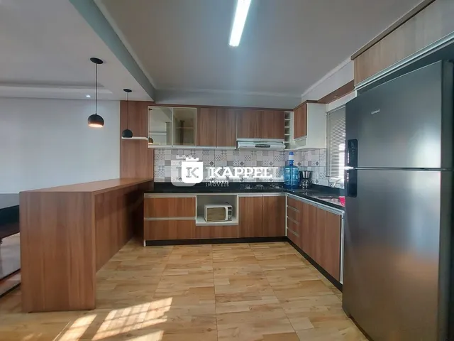 Cozinha moderna com armários de madeira e piso de madeira clara.