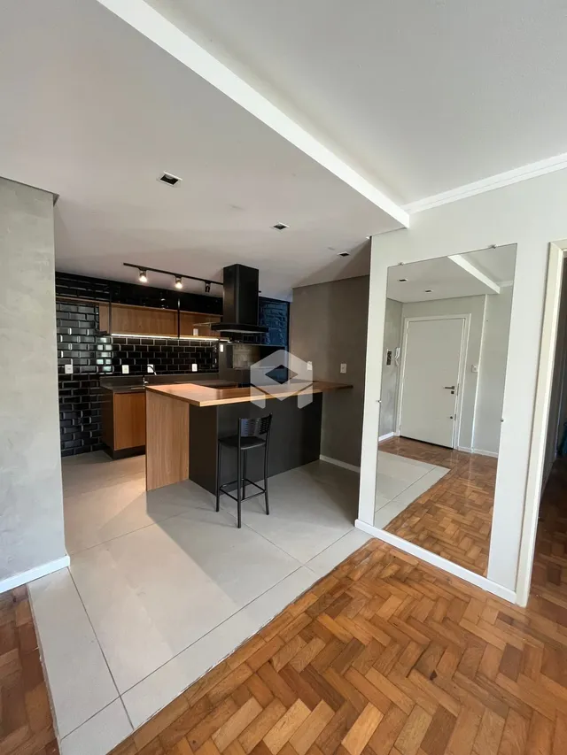 Foto da cozinha e sala de estar de um imóvel com piso de madeira.