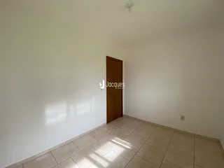 Uma sala interna com paredes brancas e piso de cerâmica.
