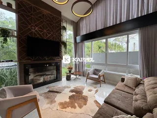 Sala de estar com lareira e grandes janelas.