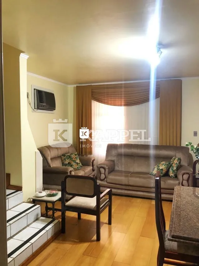 Foto de uma sala de estar com sofá e piso de madeira clara.