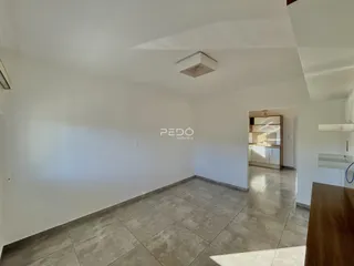Imagem de uma área interna ampla com piso de cerâmica clara.
