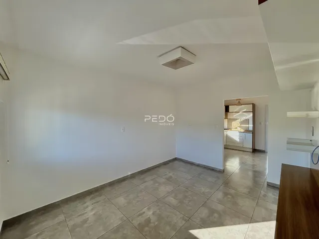 Imagem de uma área interna ampla com piso de cerâmica clara.