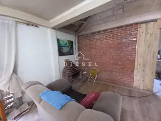 Sala com sofá e parede de tijolos aparentes.