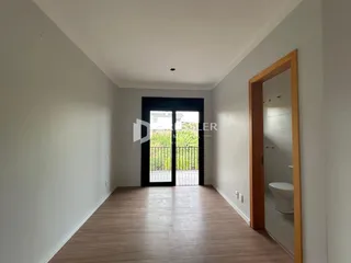 Hall de entrada com piso de madeira e portas de vidro.