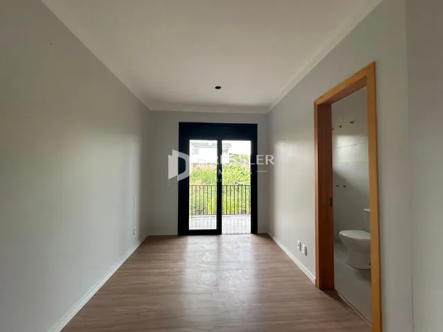 Hall de entrada com piso de madeira e portas de vidro.