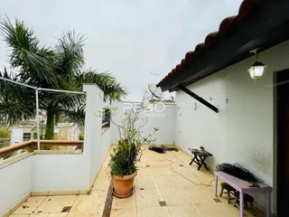 Vista externa de um pátio com piso de cerâmica e vegetação em Lajeado.