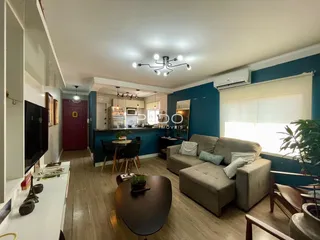 Interior de uma sala de estar com cozinha aberta em um imóvel no Brasil.