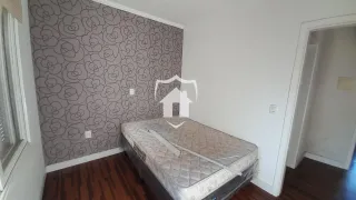 Quarto com parede decorada e piso de madeira.