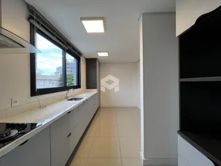 Cozinha com armários brancos e piso claro.