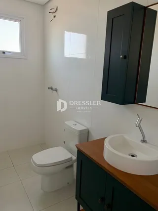 A foto mostra um banheiro com piso de cerâmica e louças brancas.