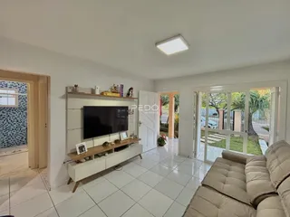 Sala de estar com piso de cerâmica e porta de vidro para o jardim.