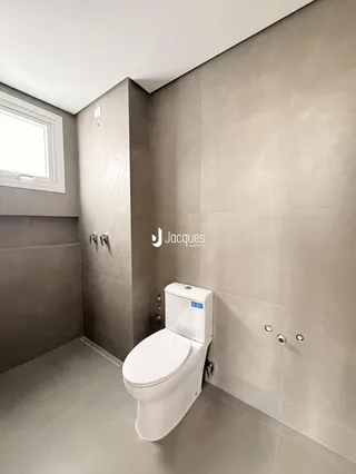 A foto mostra o interior de um banheiro com revestimento cerâmico.