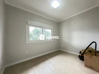 Foto de um cômodo interno com uma janela e piso de madeira.