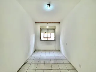 Corredor interno com piso de cerâmica e paredes brancas.