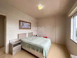 Quarto com cama e cabeceira em um imóvel.