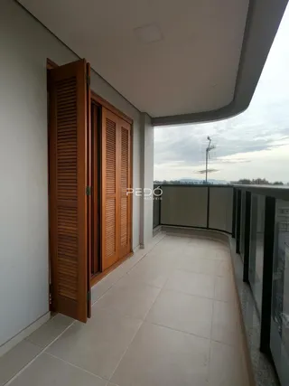 Vista de uma varanda com piso de cerâmica e porta de madeira.