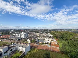 Vista aérea de uma área residencial em Lajeado, Brasil, mostrando casas e vegetação.