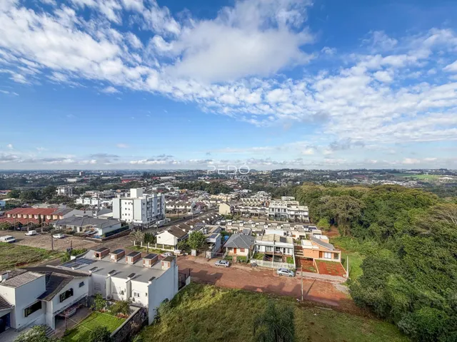 Vista aérea de uma área residencial em Lajeado, Brasil, mostrando casas e vegetação.