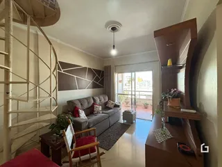 Sala de estar com sofá e escadaria em ambiente residencial.