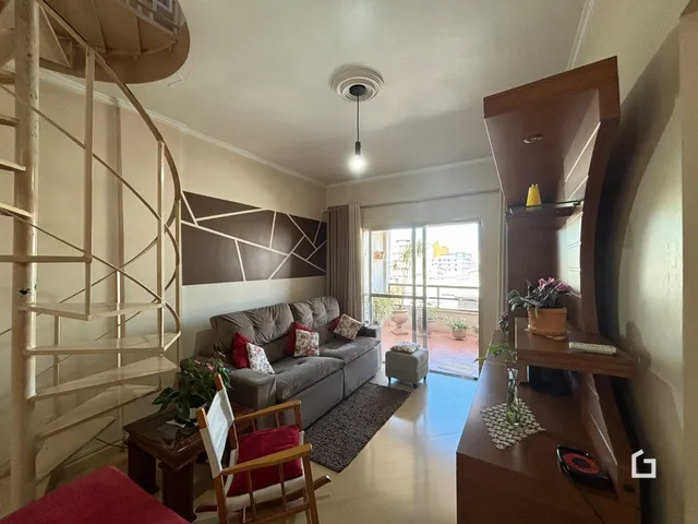 Sala de estar com sofá e escadaria em ambiente residencial.