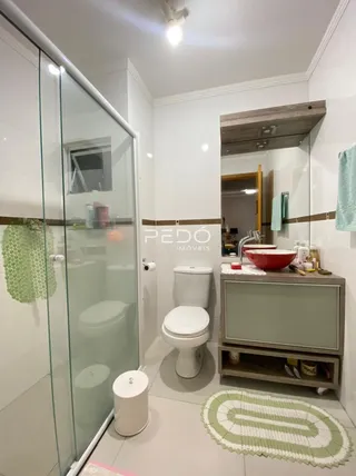 A foto mostra o interior de um banheiro com azulejos brancos.