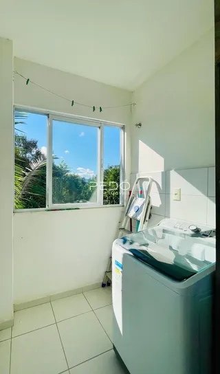 Vista interna de um cômodo com grande janela e piso de cerâmica.