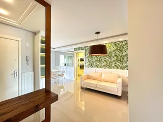 Sala de estar com paredes brancas e papel de parede verde na Lajeado.