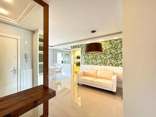 Sala de estar com paredes brancas e papel de parede verde na Lajeado.