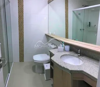Foto de um banheiro mostrando um vaso sanitário e uma pia com bancada.