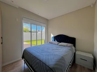 Quarto com cama grande e porta de vidro que dá acesso ao exterior.
