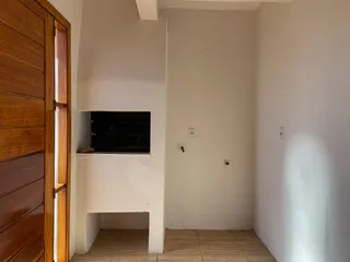 Hall de entrada com parede branca e piso de cerâmica.