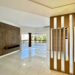 Sala ampla com piso claro e vista externa.