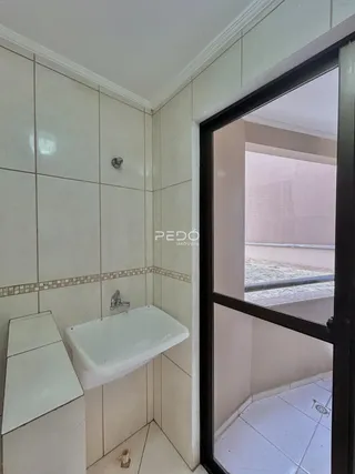 Interior de um banheiro com revestimento cerâmico branco.