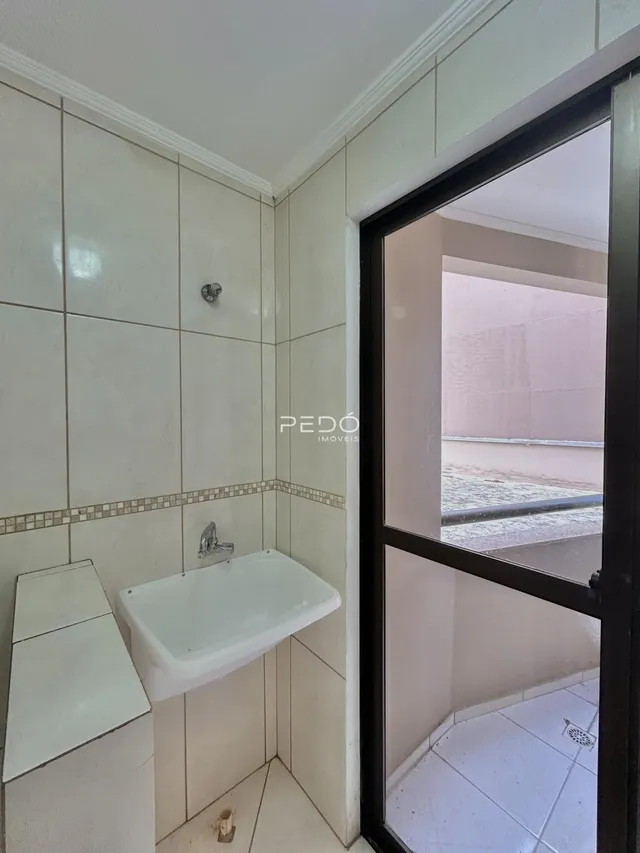 Interior de um banheiro com revestimento cerâmico branco.