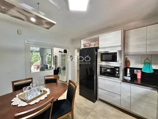Uma área de jantar com mesa de madeira é visível no interior da propriedade.