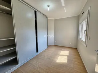 Interior de um ambiente com armários embutidos e piso de madeira clara.